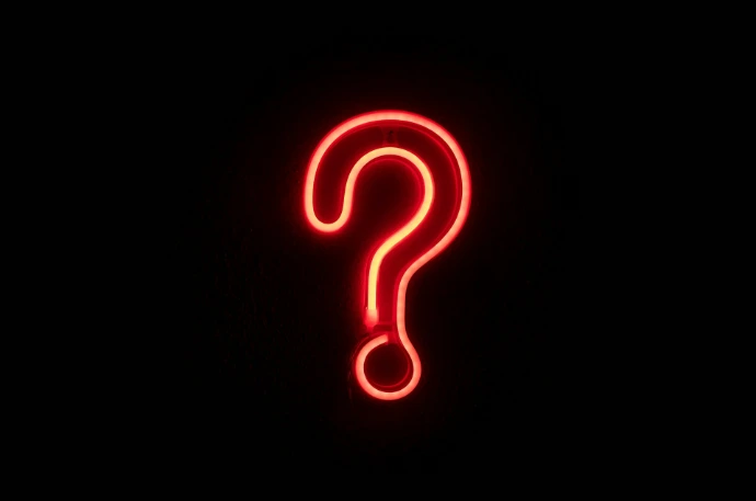 red neon question mark on black wall